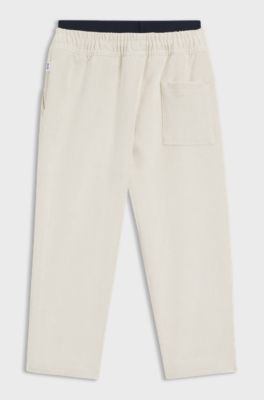 Kids' loose-fit tracksuit bottoms in stretch velvet, Light Beige