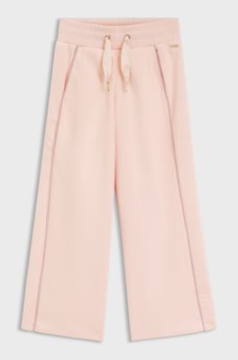 Kids' tracksuit bottoms with logo plaque, light pink