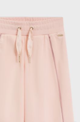 Kids' tracksuit bottoms with logo plaque, light pink