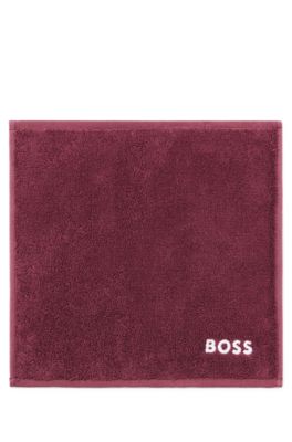 Ansiktshandduk i bomull med broderad vit logga, M&ouml;rklila