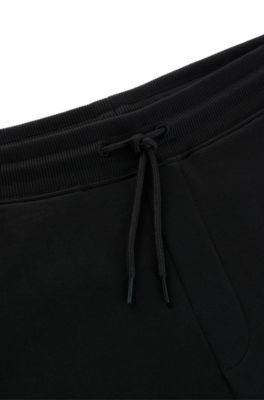 Pantalones de ch&aacute;ndal en felpa de algod&oacute;n con etiqueta con logo roja, Negro