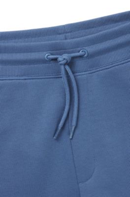 Pantalones de ch&aacute;ndal en felpa de algod&oacute;n con etiqueta con logo roja, Celeste