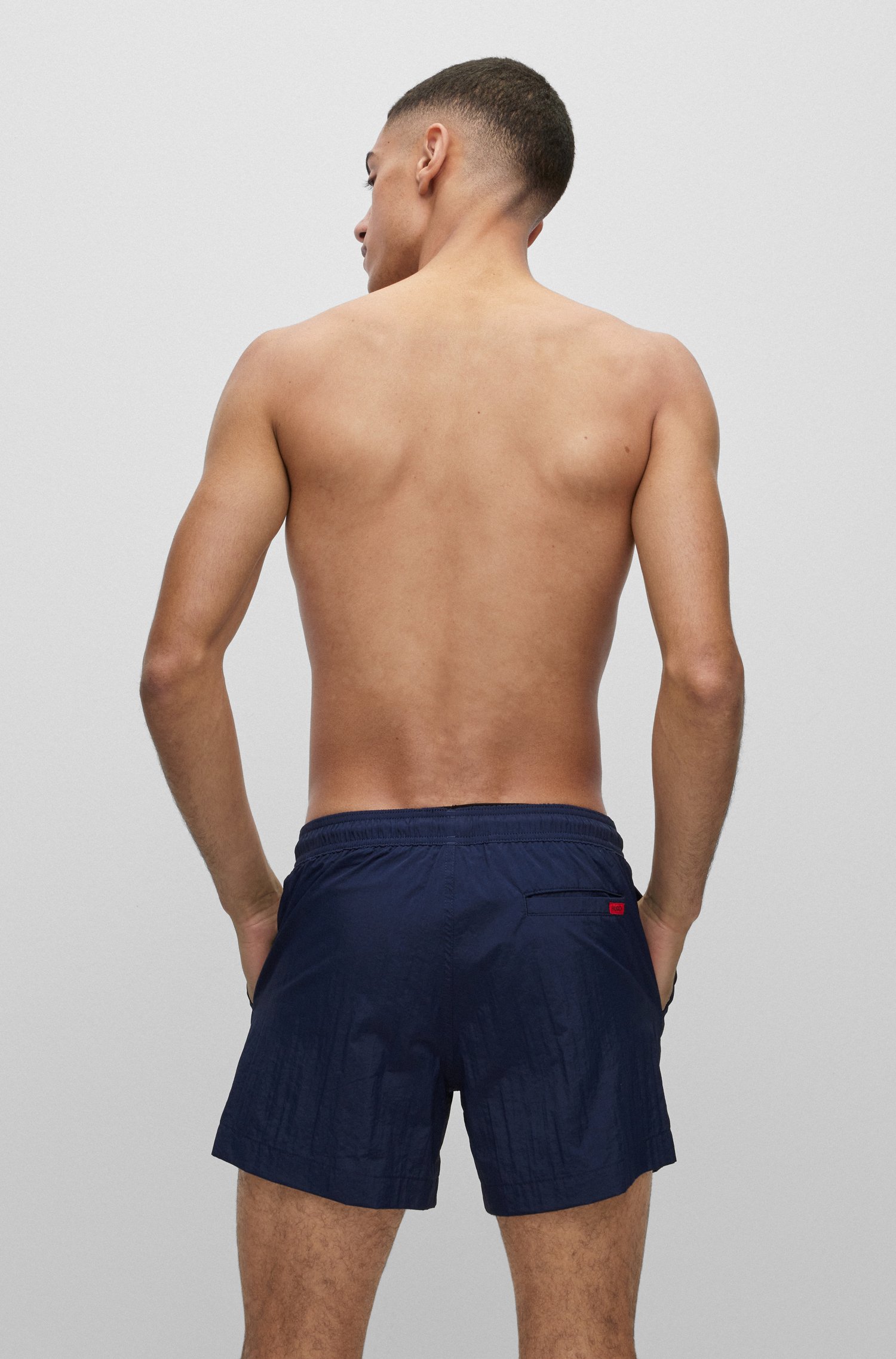 Bañador tipo shorts de secado rápido con etiqueta logo roja