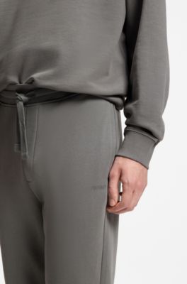 Pantalones de ch&aacute;ndal en felpa de algod&oacute;n con pu&ntilde;os y logo estampado, Gris oscuro