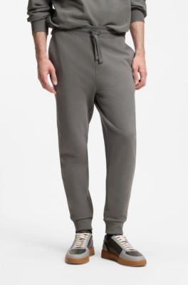 Pantalones de ch&aacute;ndal en felpa de algod&oacute;n con pu&ntilde;os y logo estampado, Gris oscuro