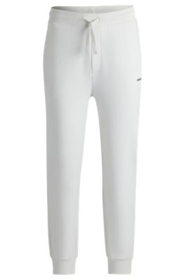 Pantalones de ch&aacute;ndal en felpa de algod&oacute;n con pu&ntilde;os y logo estampado, Blanco
