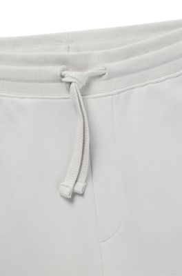 Pantalones de ch&aacute;ndal en felpa de algod&oacute;n con pu&ntilde;os y logo estampado, Blanco