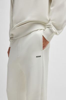 Pantalones de ch&aacute;ndal en felpa de algod&oacute;n con pu&ntilde;os y logo estampado, Blanco