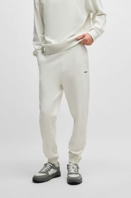 Pantalones de ch&aacute;ndal en felpa de algod&oacute;n con pu&ntilde;os y logo estampado, Blanco
