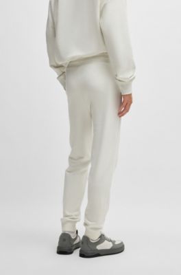 Pantalones de ch&aacute;ndal en felpa de algod&oacute;n con pu&ntilde;os y logo estampado, Blanco