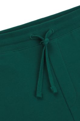 Pantalones de ch&aacute;ndal en felpa de algod&oacute;n con pu&ntilde;os y logo estampado, Verde oscuro