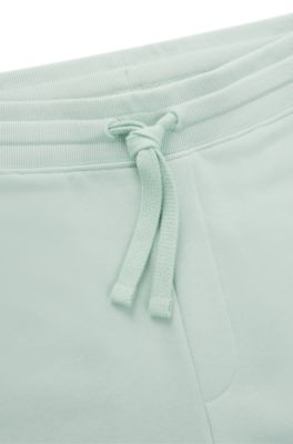 Pantalones de ch&aacute;ndal en felpa de algod&oacute;n con pu&ntilde;os y logo estampado, Cal