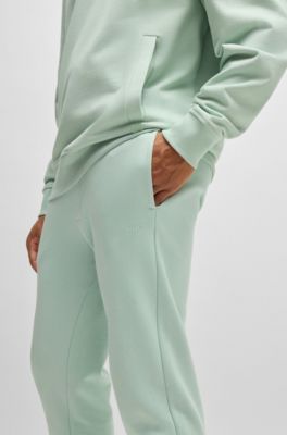 Pantalones de ch&aacute;ndal en felpa de algod&oacute;n con pu&ntilde;os y logo estampado, Cal