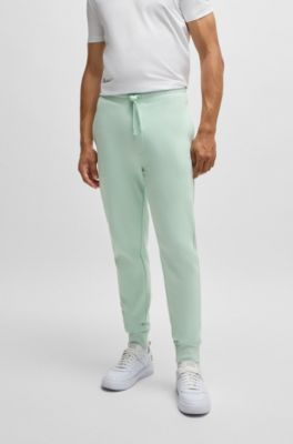 Pantalones de ch&aacute;ndal en felpa de algod&oacute;n con pu&ntilde;os y logo estampado, Cal