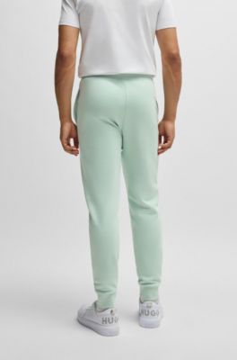 Pantalones de ch&aacute;ndal en felpa de algod&oacute;n con pu&ntilde;os y logo estampado, Cal