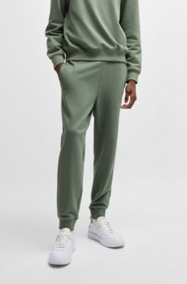 Pantalones de ch&aacute;ndal en felpa de algod&oacute;n con pu&ntilde;os y logo estampado, Cal