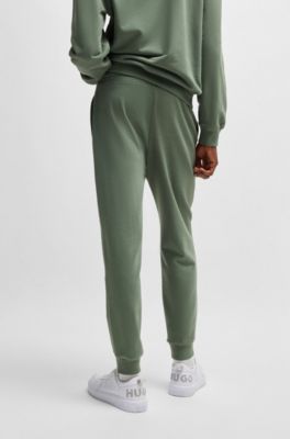 Pantalones de ch&aacute;ndal en felpa de algod&oacute;n con pu&ntilde;os y logo estampado, Cal