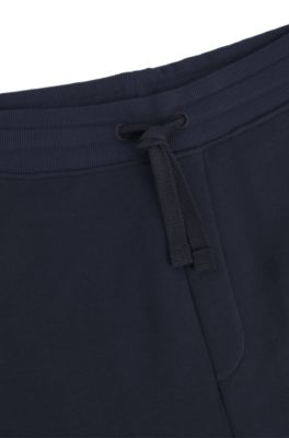 Pantalones de ch&aacute;ndal en felpa de algod&oacute;n con pu&ntilde;os y logo estampado, Azul oscuro
