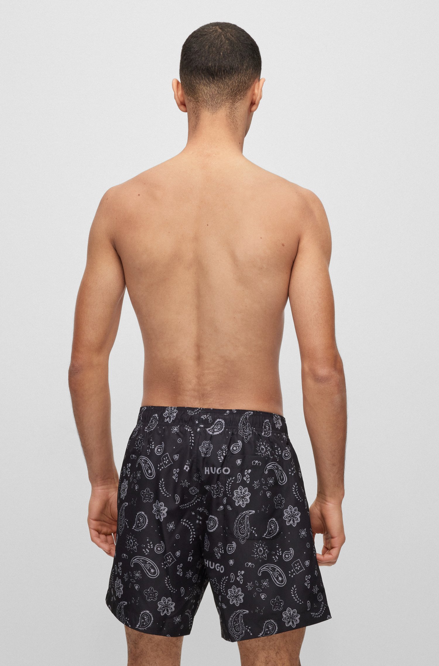 Bañador tipo shorts con estampado de logos y diseño Paisley