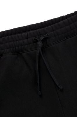 Pantalones de ch&aacute;ndal de felpa de algod&oacute;n con logo con llamas en relieve, Negro
