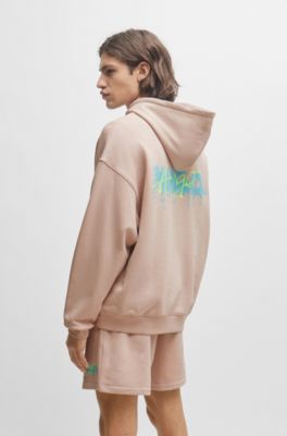 Cotton-terry oversize-fit hoodie with seasonal logos, light pink