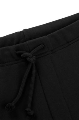 Pantalones de ch&aacute;ndal relaxed fit con logo floral de dise&ntilde;o, Negro