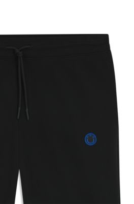 Cotton-terry tracksuit bottoms with Happy HUGO, Black