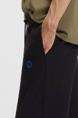 Cotton-terry tracksuit bottoms with Happy HUGO, Black
