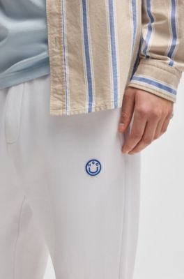 Cotton-terry tracksuit bottoms with Happy HUGO, White