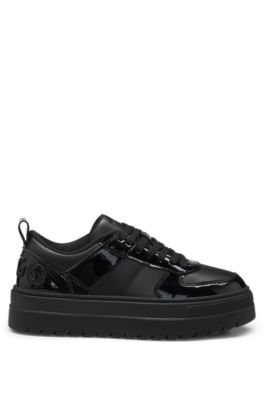 Platform-sole lace-up trainers with patent details, Black