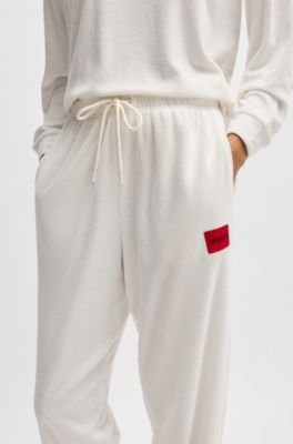 Tracksuit bottoms with red logo label, White