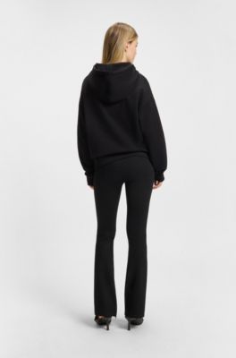 Pantalones relaxed fit en tejido el&aacute;stico con pernera acampanada, Negro