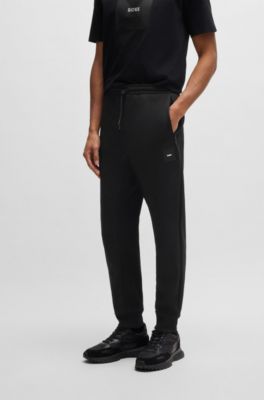 Pantalones de ch&aacute;ndal en algod&oacute;n el&aacute;stico con parche de logo, Negro
