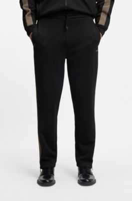 Pantalones de ch&aacute;ndal relaxed fit con cinta de logos, Negro