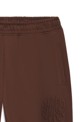 Pantalones de ch&aacute;ndal loose fit de felpa de algod&oacute;n con ilustraci&oacute;n de logo, Marr&oacute;n