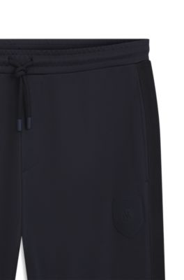 Pantalones de ch&aacute;ndal regular fit con escudo con logo, Azul oscuro