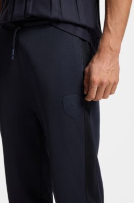 Pantalones de ch&aacute;ndal regular fit con escudo con logo, Azul oscuro