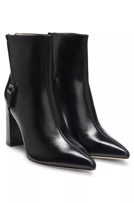 Pointed-toe boots in glossy leather with buckle detail