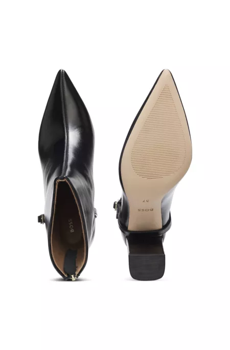 Pointed-toe boots in glossy leather with buckle detail