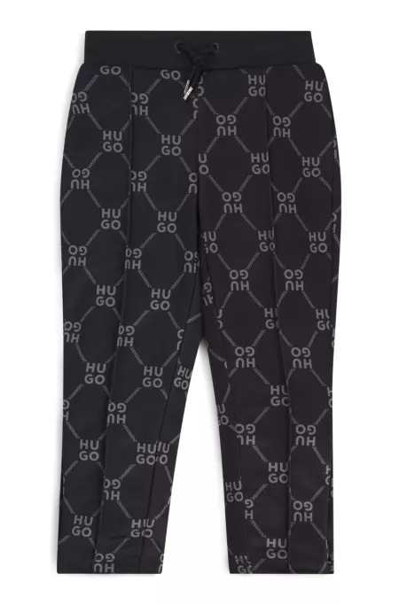 Kids' loose-fit tracksuit bottoms with stacked-logo print