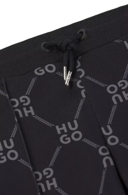 Kids' loose-fit tracksuit bottoms with stacked-logo print