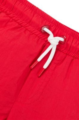 Kids' swim shorts with red logo label, Red