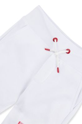 Kids' fleece tracksuit bottoms with marker-style logo, White
