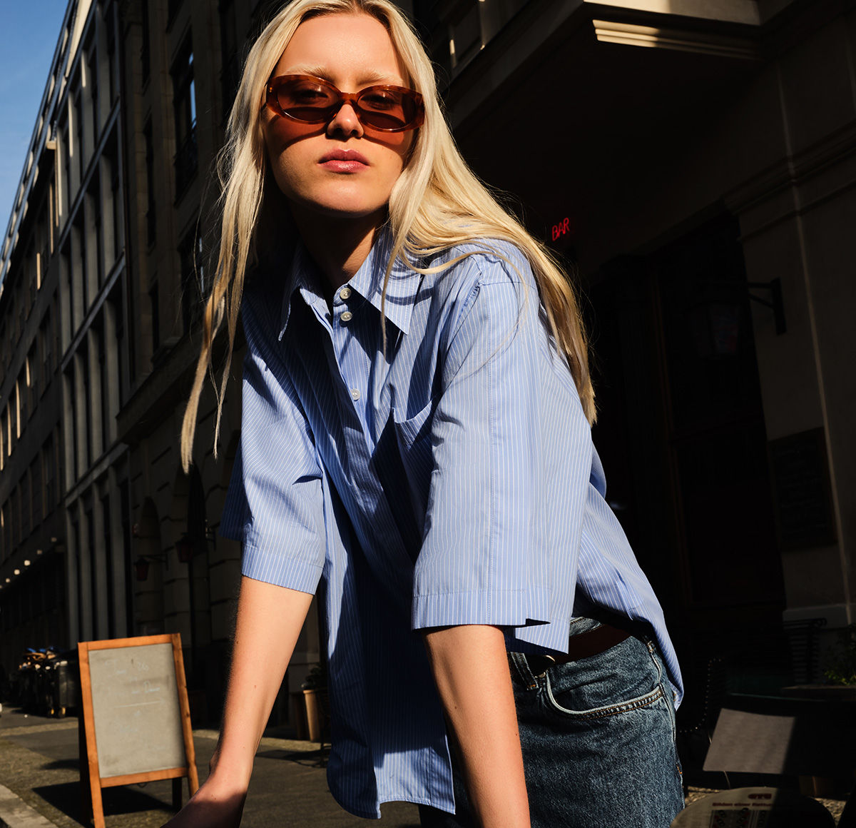 Women is wearing blue blouse by BOSS