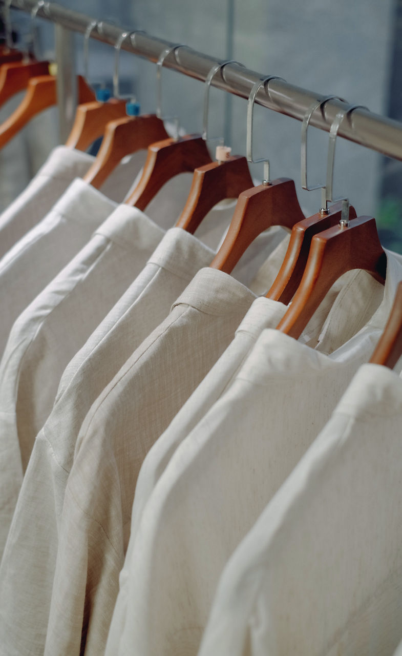 Photo d’un homme qui mesure une chemise afin de trouver la taille qui lui convient
