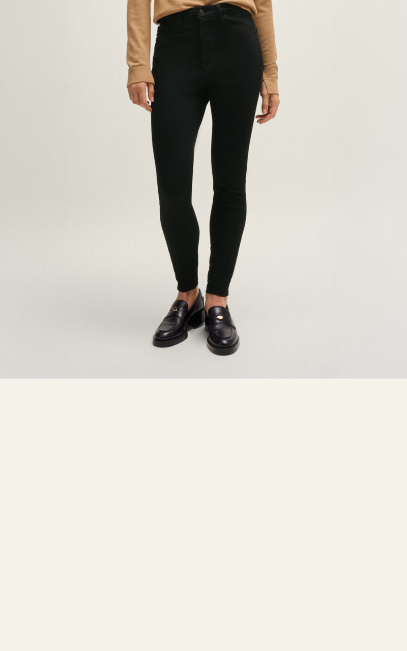 Model wearing a  slim fit jeans trousers showing fit from back and front 