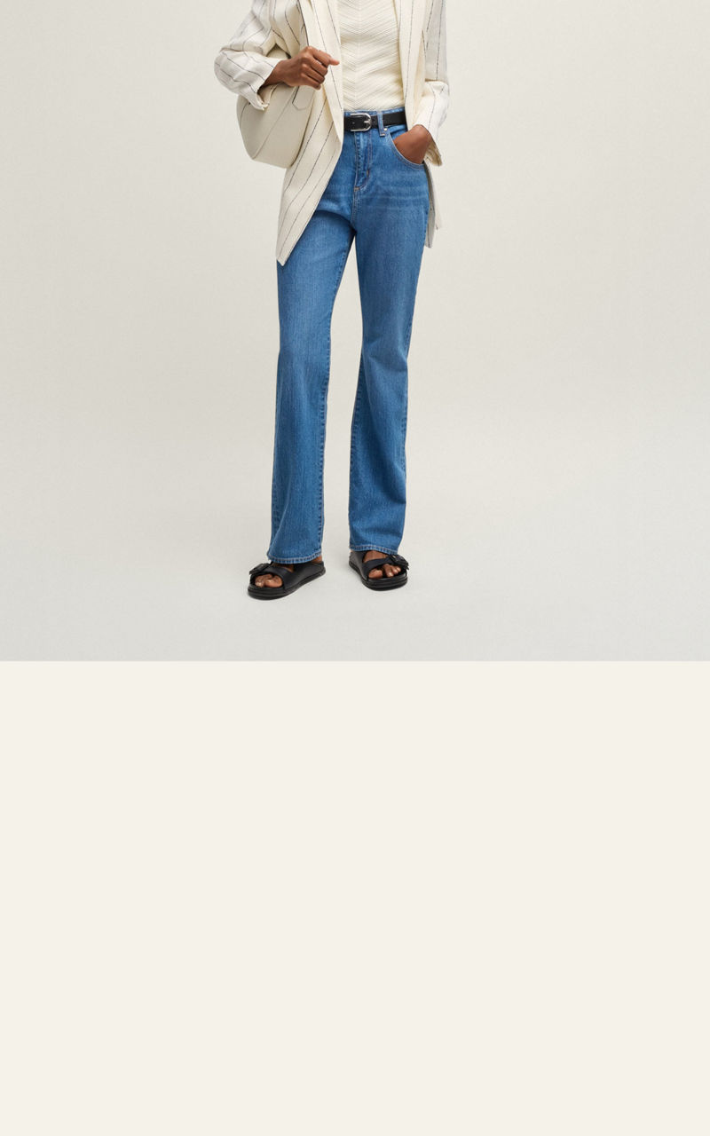 Model wearing a tapered fit jeans trousers showing fit from back and front 