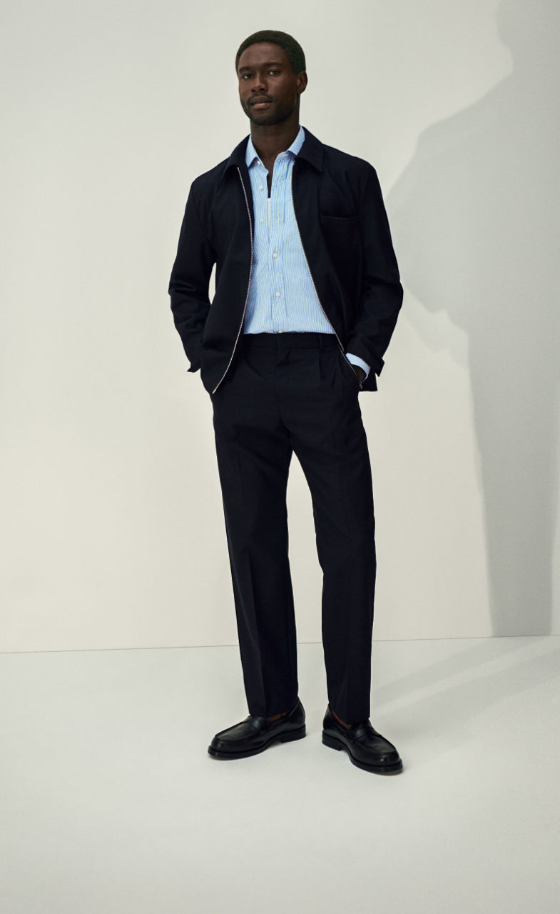Business Outfit featuring a blue striped shirt a navy jacket and a navy wool suit pats pairend with loafers