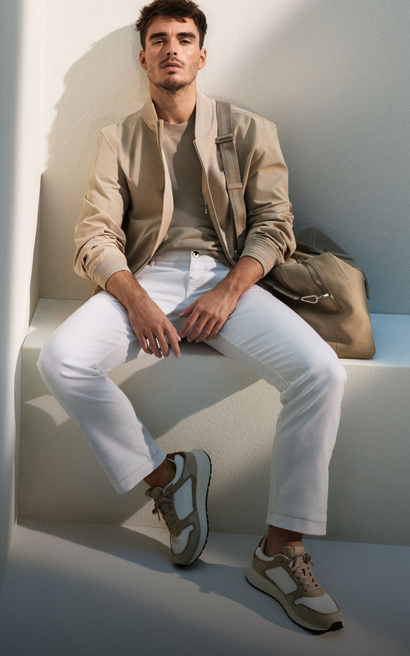 manlig modell som sitter på en bänk presenterar BOSS denim