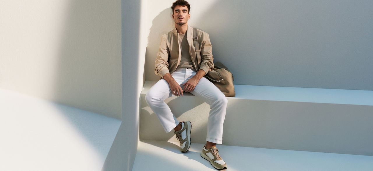 manlig modell som sitter på en bänk presenterar BOSS denim